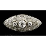 A 1920's gold and silvery coloured metal all diamond set navette pattern brooch, the central old cut