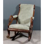 A Victorian mahogany framed scroll back rocking open armchair, the seat back and arm pads
