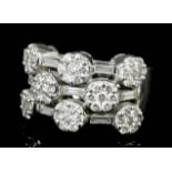 A modern 18ct white gold all diamond set triple band ring, the face with eight flowerhead pattern