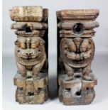 A pair of Indian or Afghanistan hardwood pedestals carved with seated mythological lions, each 20ins