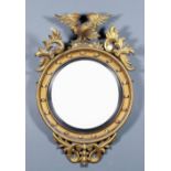 An early 19th Century gilt framed circular convex wall mirror, the moulded frame with ball