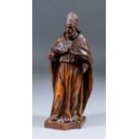 An 18th Century carved boxwood figure of a standing Bishop wearing mitre and cloak, 9ins high, (