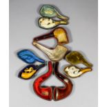 Five Meerschaum pipes and cheroot holders, including - Bird with beetle, with glass eyes and amber