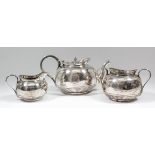 A late Victorian silver three piece tea service, the plain squat, circular bodies with bead mounts