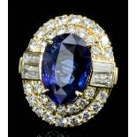 A modern 18ct gold mounted sapphire and diamond ring, the oval cut sapphire of approximately 7.