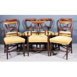 A set of four Victorian mahogany balloon back dining chairs with scroll carved splats, seats