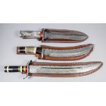 Three large Damascus steel modern hunting daggers 22,17 and 15ins overall, each with bone grips