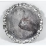 An Edward VII silver circular tray of large proportions with shaped and moulded rim, on four leaf