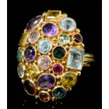 A modern gold coloured metal mounted multi gem set ring, the oval textured face 30mm x 25mm, set