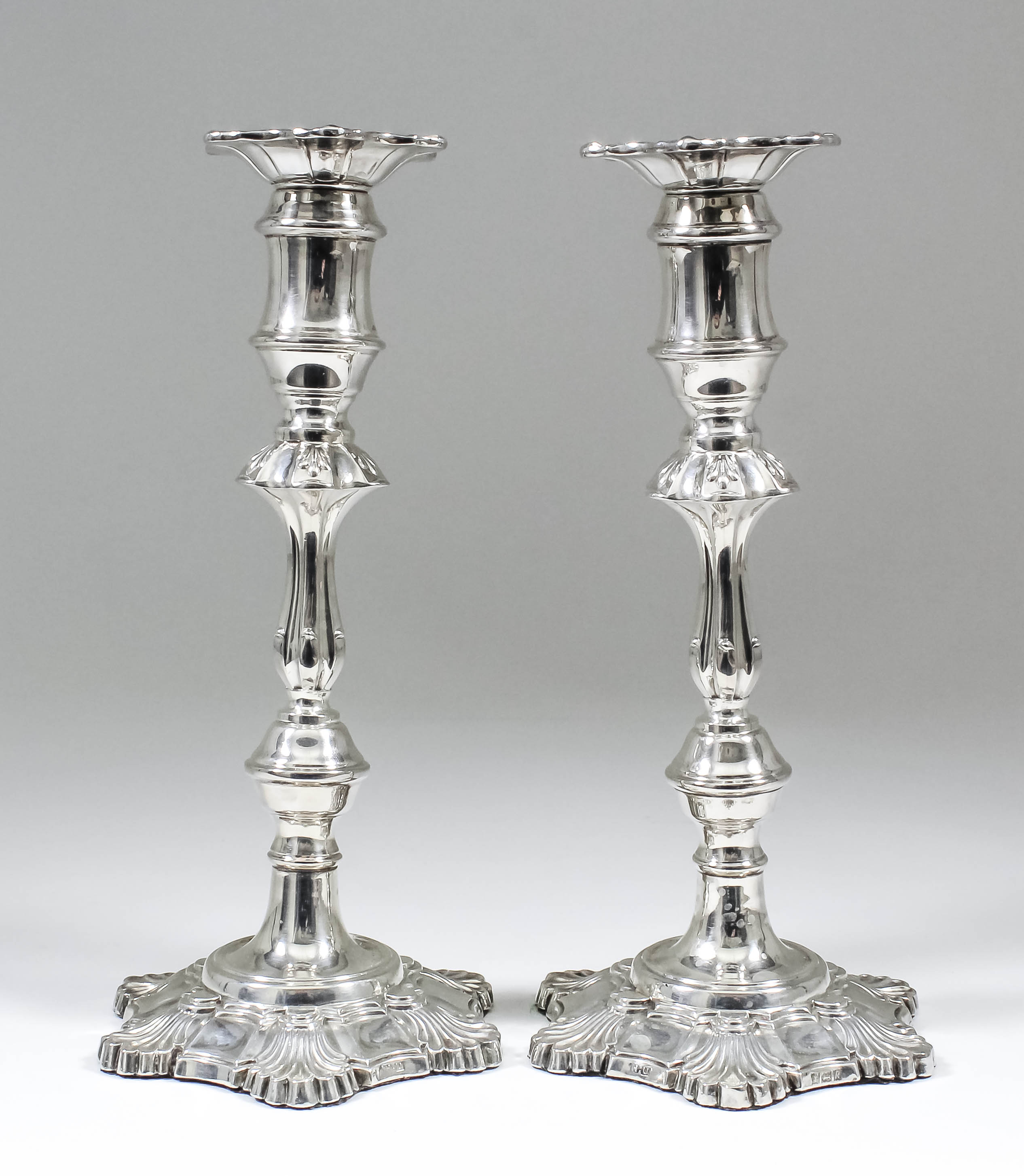 A pair of Elizabeth II silver pillar candlesticks of mid-18th Century design, with knopped stems and