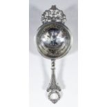 A George V silver one-handled tea strainer, the handle with cast with trellis ornament and with