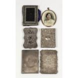 A late Victorian silver rectangular card case of shaped outline engraved with central flower, all