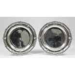 A pair of George IV silver plates, the shaped rims with bold gadroon and shell pattern mounts, 10.