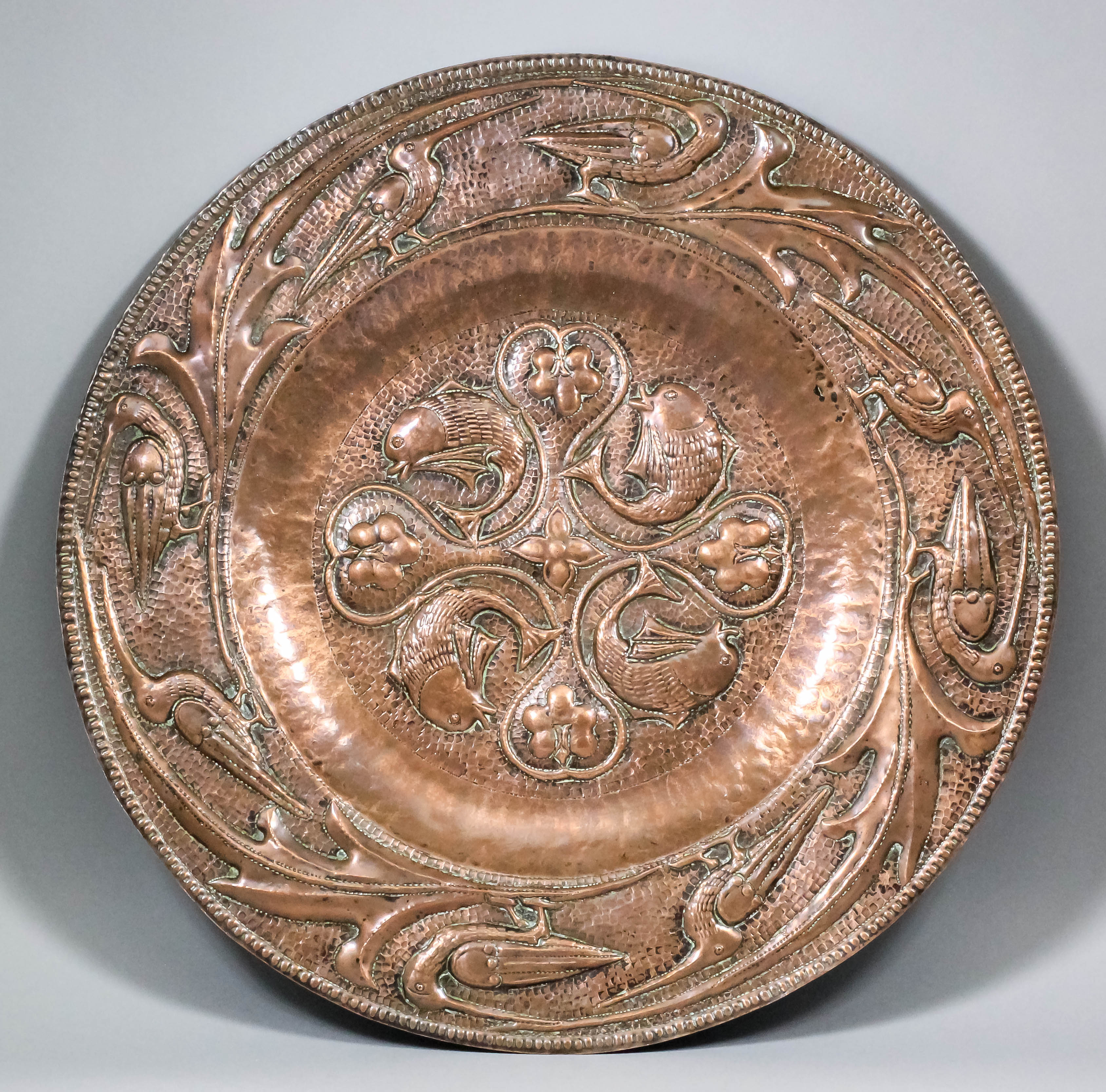 An early 20th Century Arts and Crafts embossed copper circular charger by John Pearson (1859-1930)
