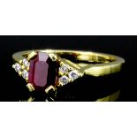 A modern 18ct gold mounted ruby and diamond ring, the central emerald cut ruby of approximately 1.