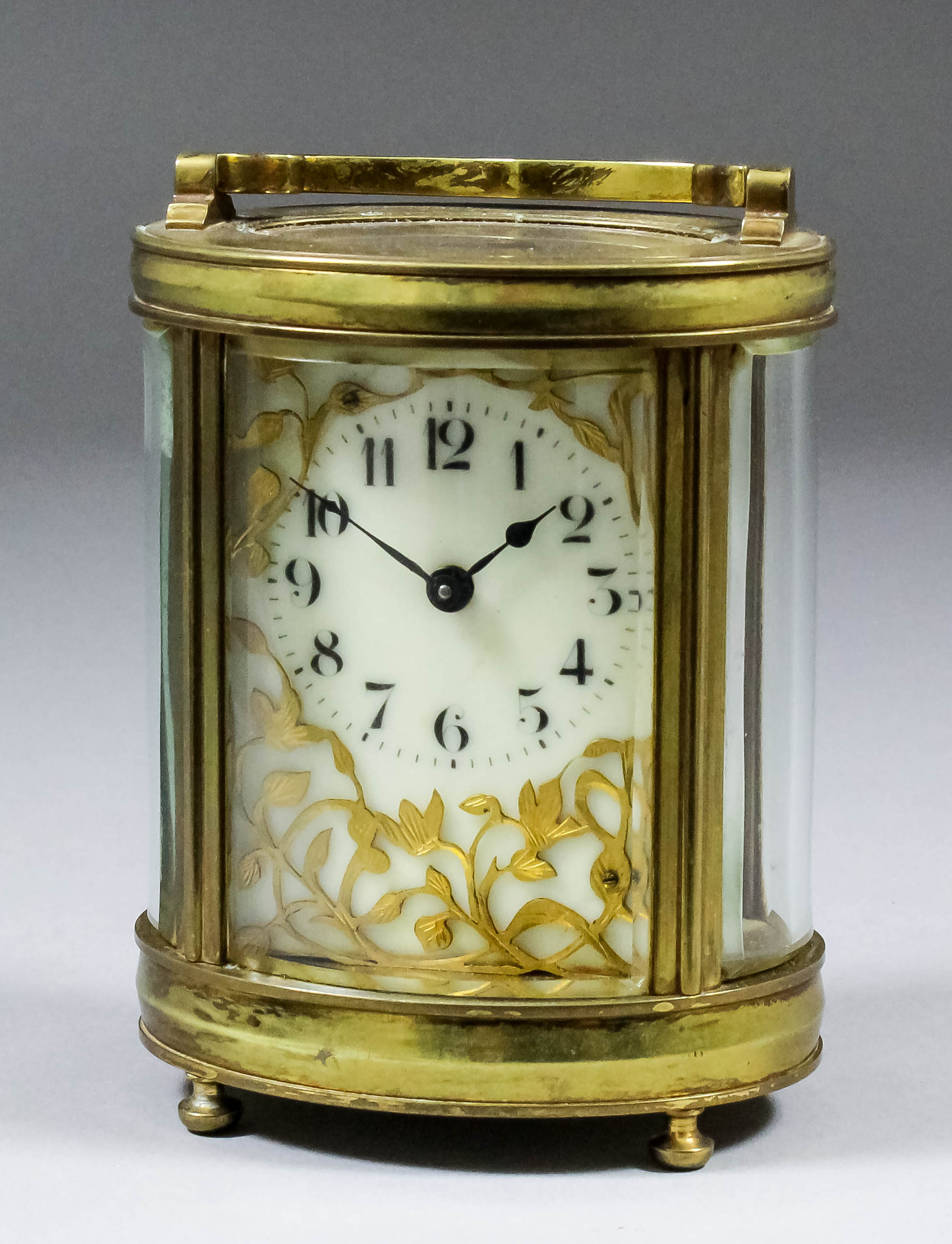 An early 20th Century French oval carriage timepiece, the cream enamel dial with Arabic numerals,