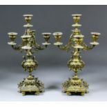 A pair of late 19th Century Continental gilt brass five light candelabra with scroll branches and