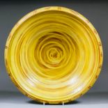 Clive Bowen (born 1943) - Large lead glazed pottery charger painted with yellow slip on a red body
