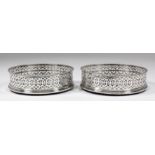 A pair of George III silver circular coasters with bead mounts and C-scroll pierced sides, with