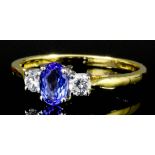 A modern 18ct white and yellow gold mounted sapphire and diamond ring, the central oval cut sapphire