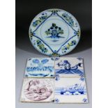 An English 18th Century Delft plate painted in colours with a vase of flowers, the rim with trailing