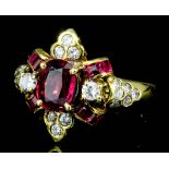 A modern 18ct gold mounted ruby and diamond ring, the central oval cut ruby of approximately .