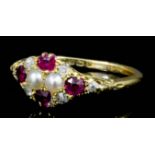 A George V 18ct gold mounted seed pearl, diamond and ruby set ring, the face set with four small