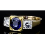 A modern gold and silvery coloured metal mounted sapphire and diamond set three stone ring, the oval