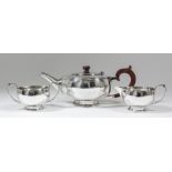 A George V silver three piece tea service with plain circular squat bodies, comprising - teapot with