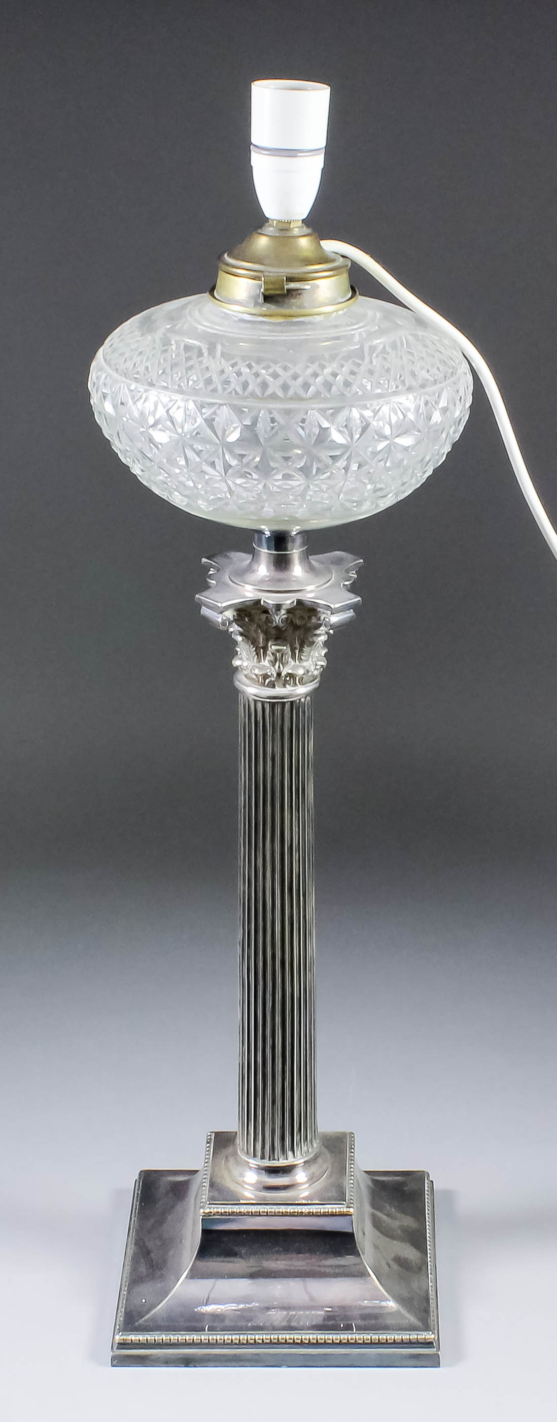 A plated table oil lamp of Corinthian column form, on stepped square base with bead mounts and