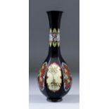 A Japanese cloisonne bottle vase of panelled form, the sides with flowering branches within shaped