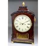 An early 19th Century mahogany mantel clock, the 8ins diameter painted domed metal dial with Roman