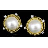 A pair of modern gold coloured metal mounted pearl and diamond set earrings (for pierced ears),