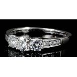 A modern 14ct white gold mounted three stone diamond ring, the face set with three brilliant cut