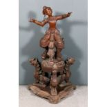 A Burmese carved hardwood figure of a female dancer, her right foot resting on a lion dog, and on
