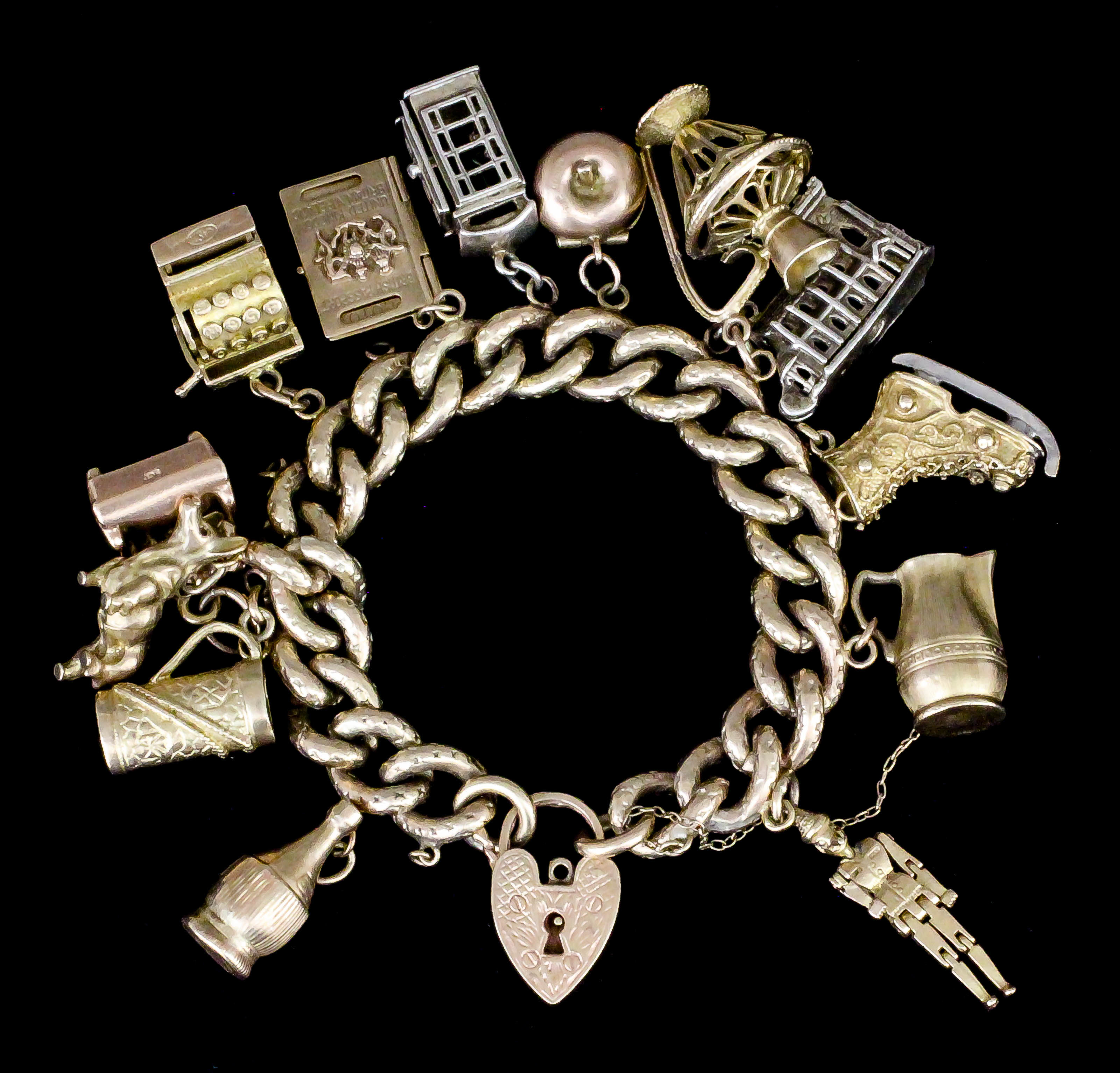 A gold coloured metal filled and engraved curb link bracelet with 9ct gold heart pattern padlock,
