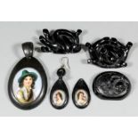 A late Victorian jet oval pattern pendant set to the centre with oval porcelain panel of young