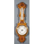 A late Victorian oak cased aneroid barometer and thermometer with 7.25ins diameter white dial, in