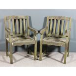 A pair of hardwood flat back garden armchairs, the slightly shaped crest rails carved with floral