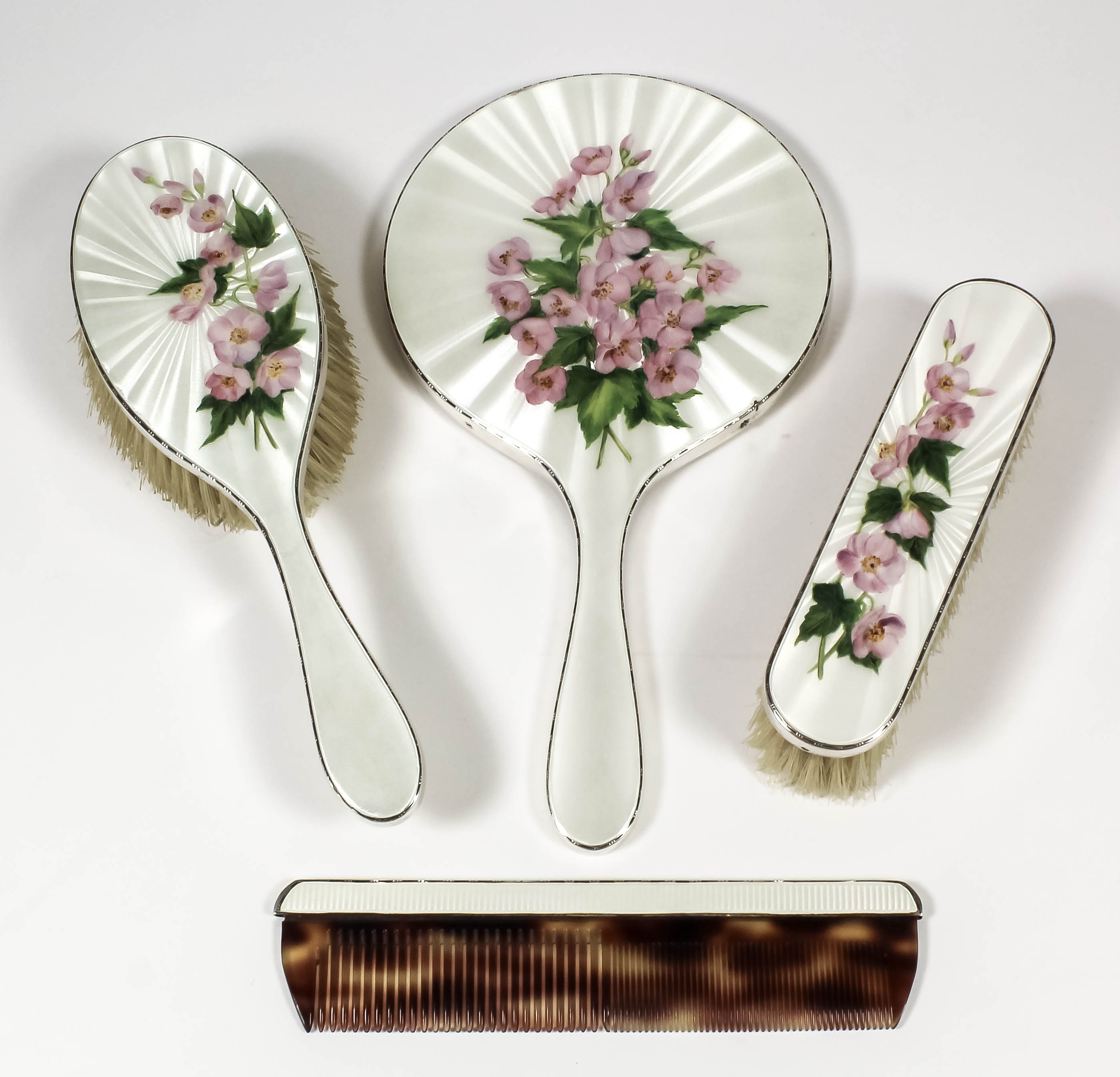 An Elizabeth II silver and cream guilloche enamel backed four piece dressing table set decorated