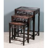 A nest of three Chinese hardwood rectangular occasional tables with panelled tops, the frieze