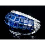 A modern silvery coloured metal mounted sapphire and diamond set Bombay pattern ring, the face set