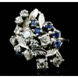 A 1960's 18ct white gold mounted sapphire and diamond flower spray ring, the face set with eleven