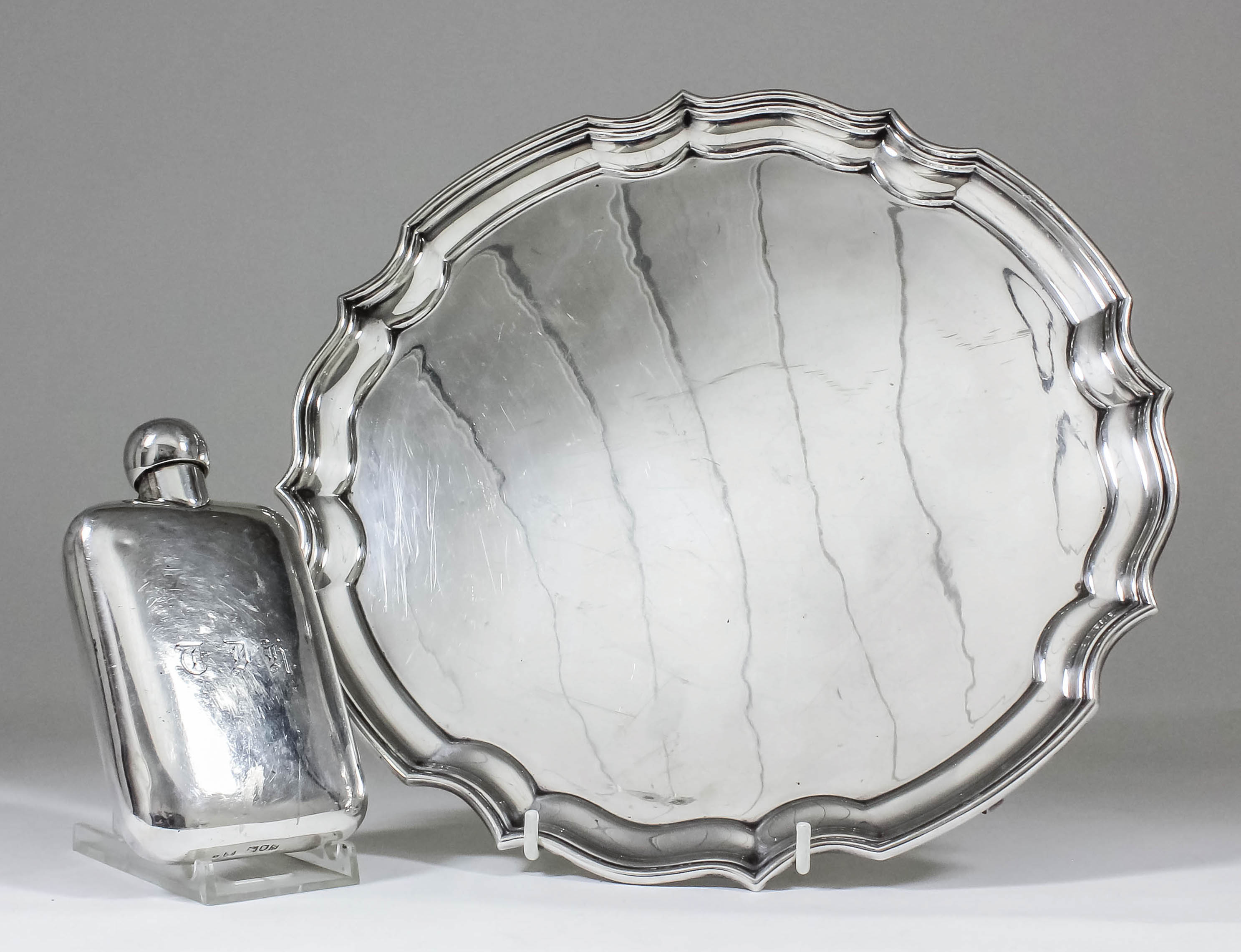 An Elizabeth II silver circular salver with shaped and moulded rim, on three scroll feet, 12ins