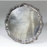 An Edward VII silver circular salver, the shaped and moulded rim with leaf cast mounts, on four