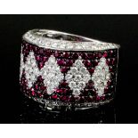 A modern 18ct white gold mounted ruby and diamond ring, the face millegrain set with five diamond