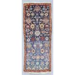 An antique Kuba long rug woven in colours with bold floral stylised geometric motifs, on a dark blue