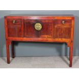 A Chinese red stained wood side cabinet enclosed by a central doors, flanked by drawers, on square