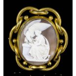 A late Victorian gilt metal mounted oval shell cameo brooch carved in high relief with a seated