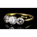 A modern 18ct gold and platinum mounted three stone diamond ring, the central brilliant cut